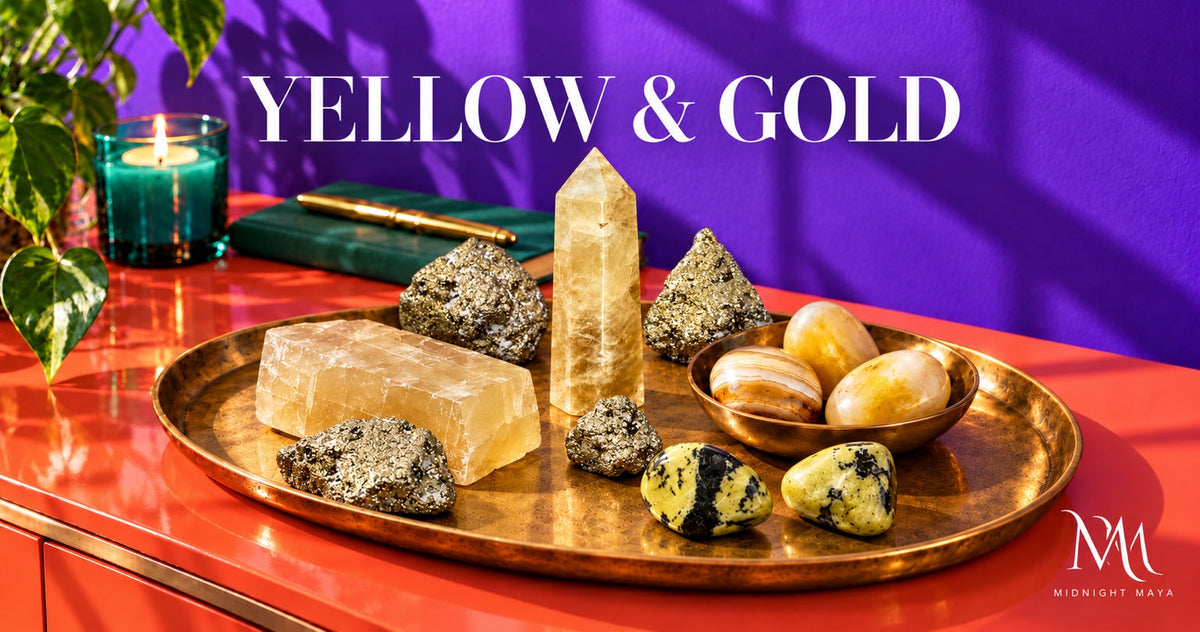 Yellow and gold crystals arranged on a brass tray against a purple backdrop.